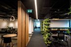 Vertical wooden spaced slats on left as partitions, walk through area, and vertical garden on right to separate workspace area