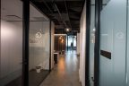 glass wall of office along corridor with waiting area and reception in background