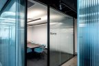 Meeting room with Glass front, dark table and light blue mid-height chairs