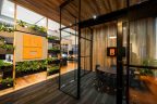 New Office Fitout Melbourne showing meeting Room with Glass wall and black frames and orange highlights to match logo