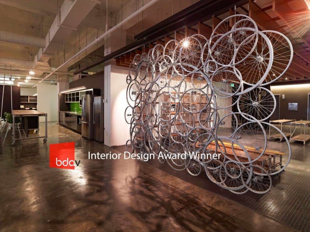 Award Winning Interior Design for The Bicycle Network showing the use of bike wheels in the design with mixed flooring, roof beams & wood accents